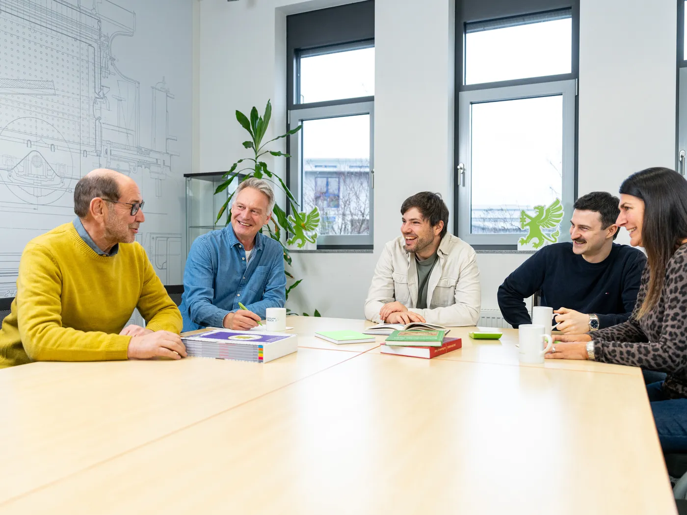 Team in Schweinfurt am Besprechungstisch mit gedruckten Büchern